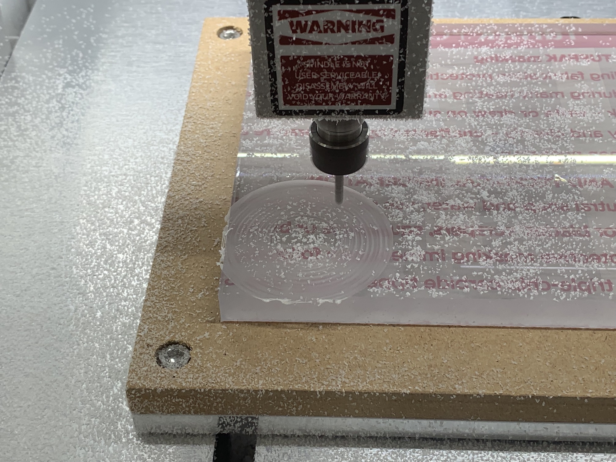 Photograph of a CNC mill cutting a thick polycarbonate sheet